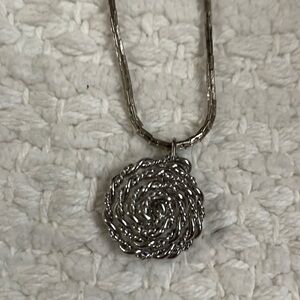 18” silver tone necklace with a flower pendant made of chain
